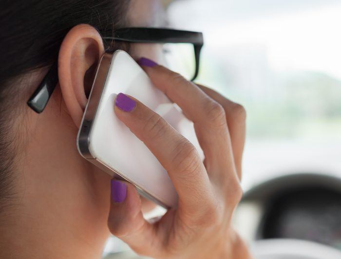 woman with glasses speaking on cell phone