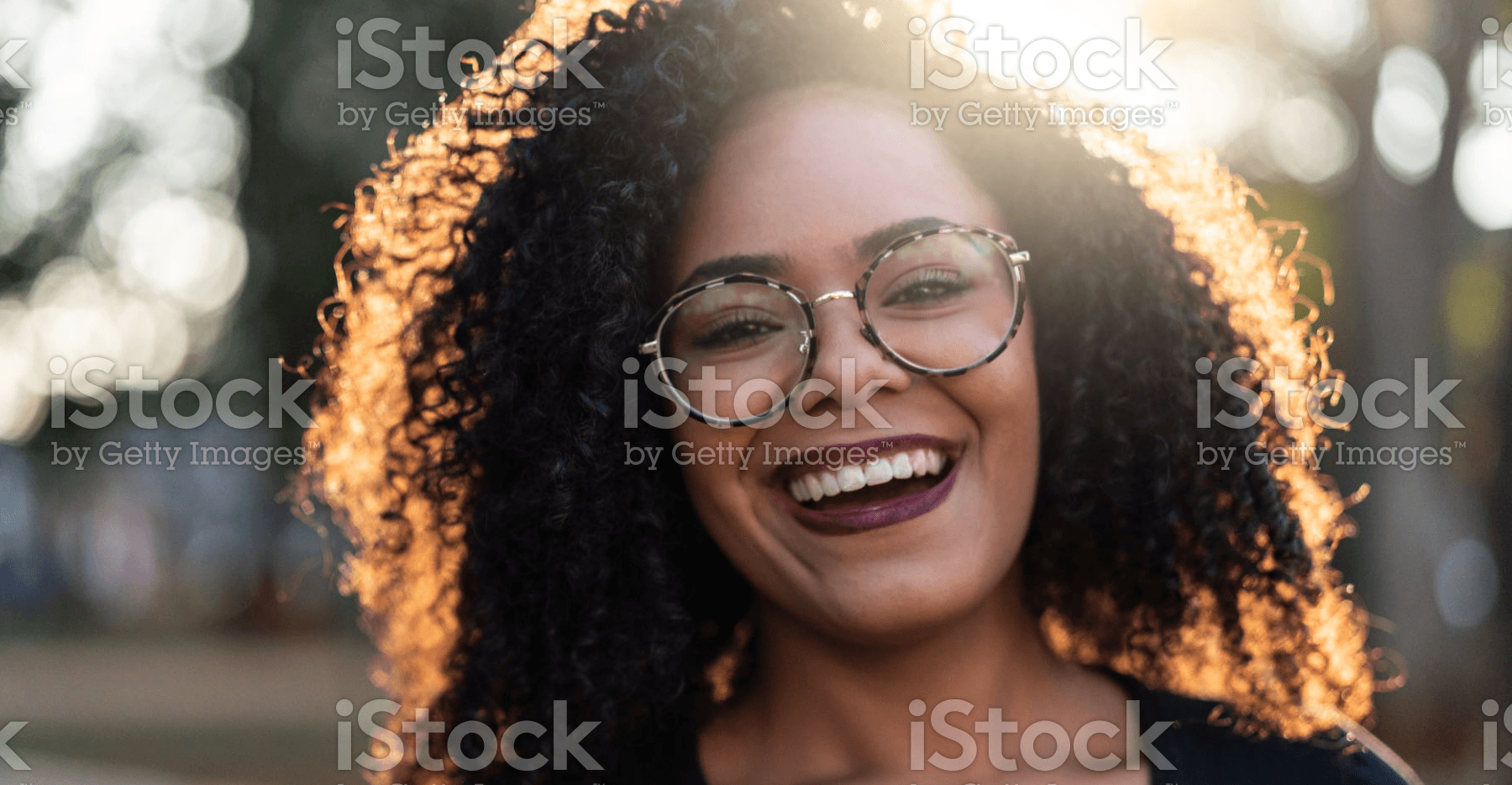 smiling woman with glasses looks at camera