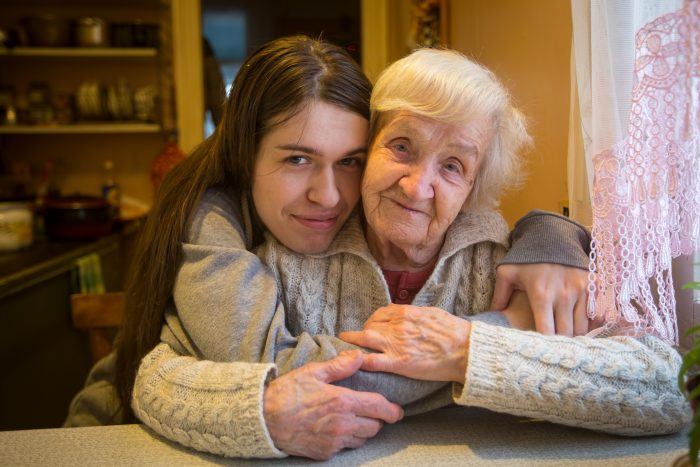 older woman being hugged by young woman