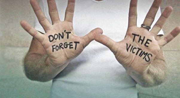 outstretched hands read "don't forget the victims"
