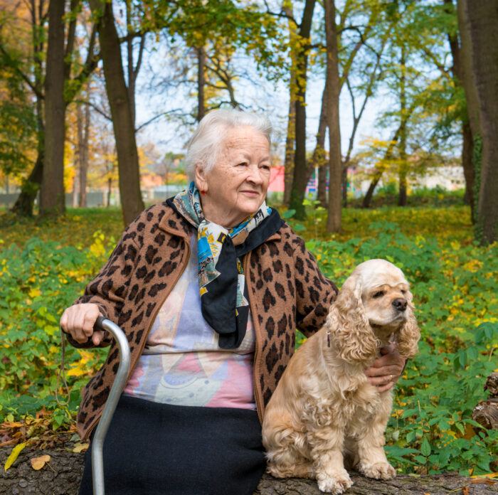 Older woman sits outside with dog, not a client image