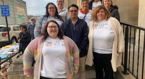 Legal Aid of West Virginia's Clarksburg office staff stand together and smile in front of First United Methodist Church in Clarksburg