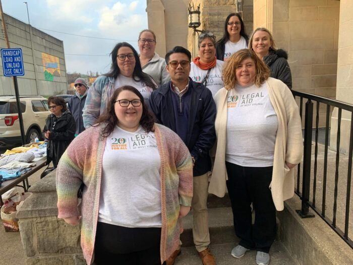 Legal Aid of West Virginia's Clarksburg office staff smile together in front of First United Methodist Church in Clarksburg