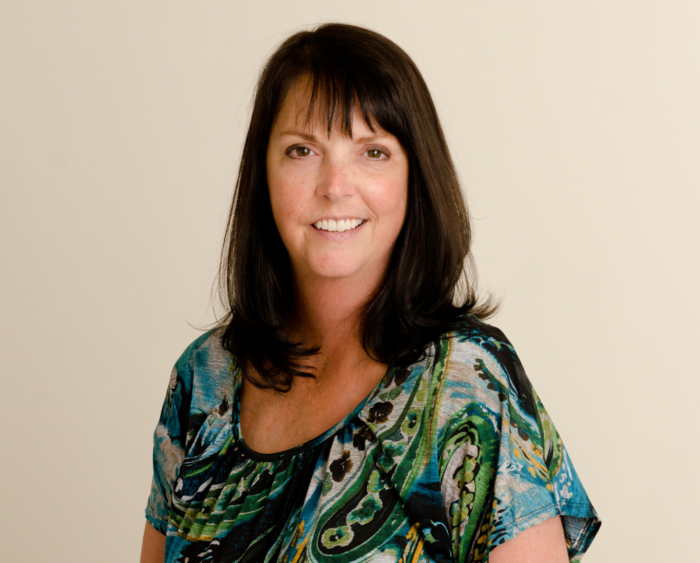 woman with brown hair smiles at camera