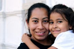 woman and child hug and look at the camera