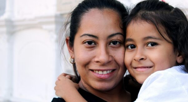 woman and child hug and look at the camera