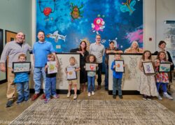 Artists stand in front of the PlaySpace mural in Legal Aid's Charleston office lobby