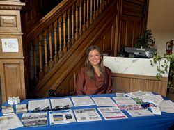 Kaylie sits at an outreach table for Legal Aid